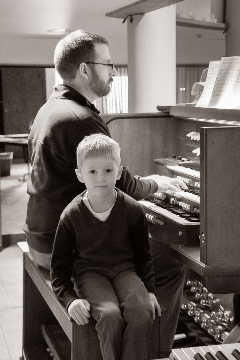 October 13, 2019:  With his young son Armin by his side, Dr. Chris Krampe, Director of Music, plays the organ for a Worship service. 