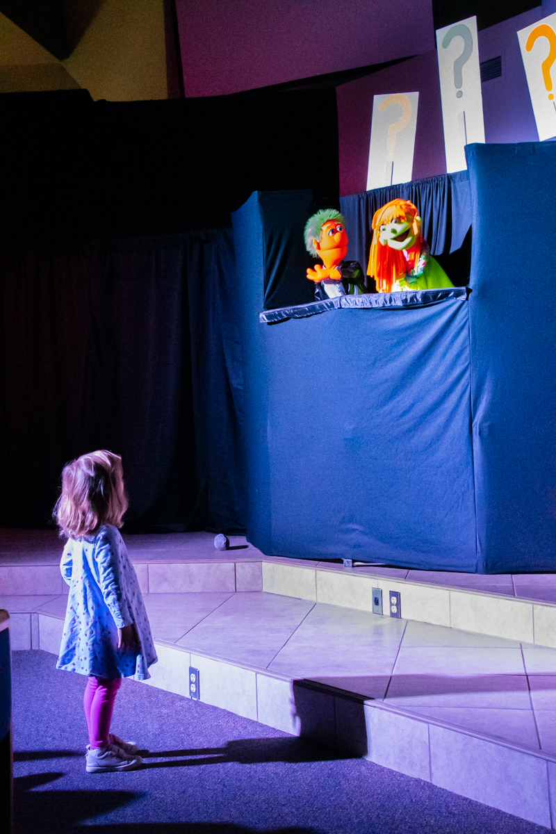 November 10, 2019:  Captivated by the puppets, a young girl wanders close for a better view during the ACE Puppet Troupe performance. 